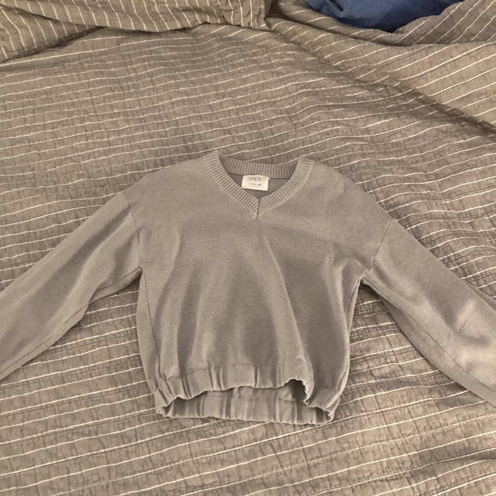 This is a gray blouse like sweater